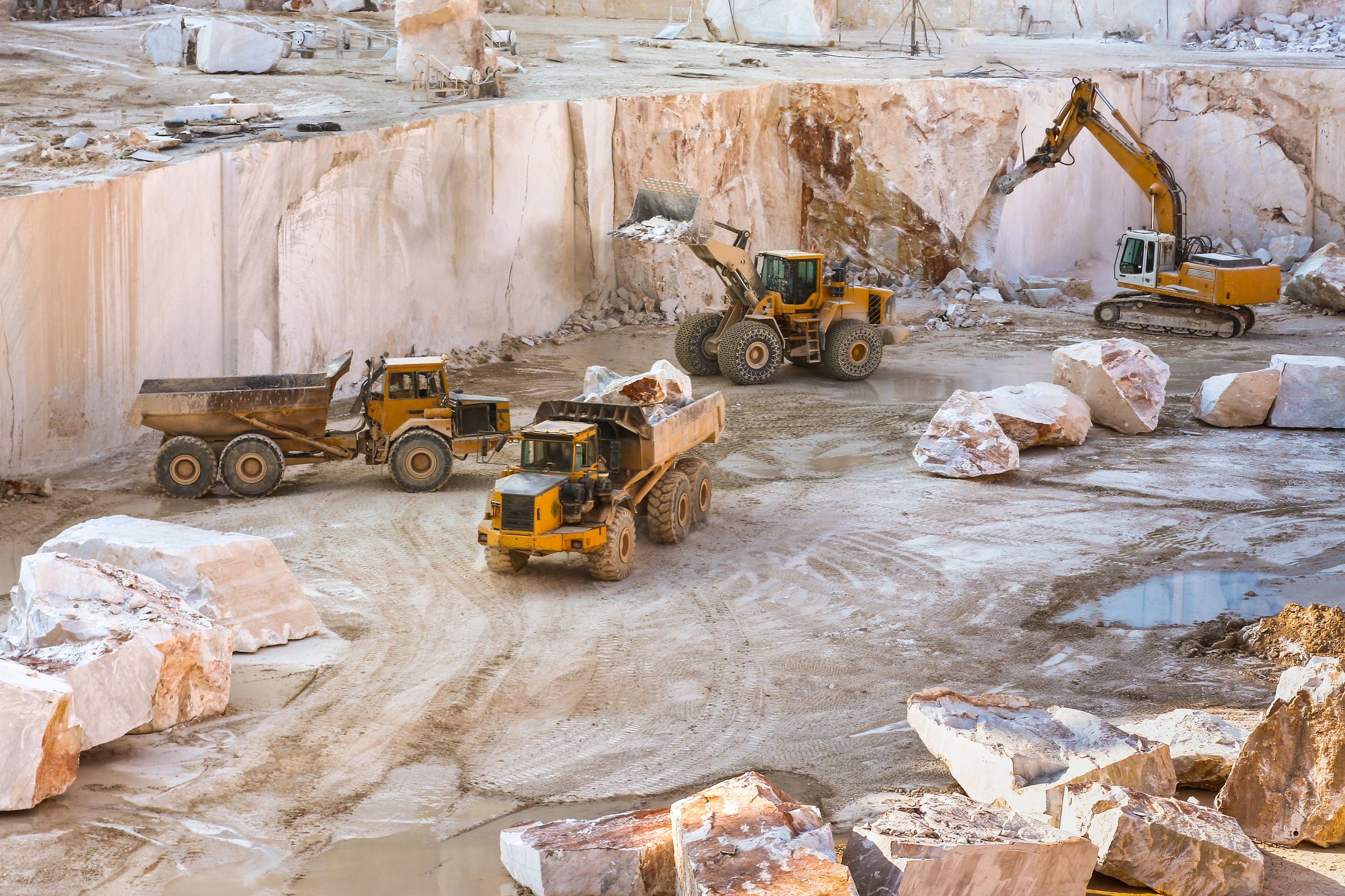 Operación minera en campo con maquinaria pesada y entorno de minería a cielo abierto